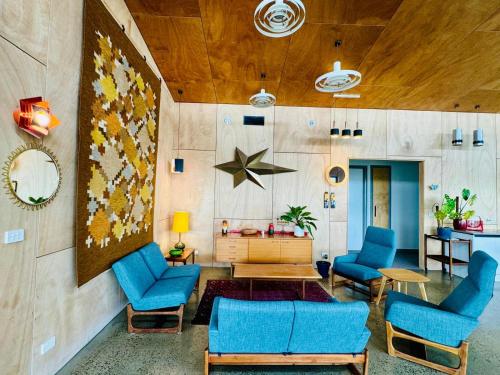 a living room with blue chairs and a table at Farmstay in Central Victoria in Ballan