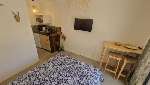 une chambre avec un lit, une table et une télévision dans l'établissement Chambre indépendante avec sdb, cuisine et terrasse, au Grau-du-Roi