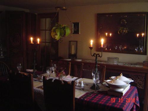 a dining room with a table with candles on it at Holdstrong Farmhouse in Lydford