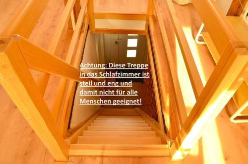 a wooden staircase with a sign on the wall at Lehmhäuschen mit Sauna in Tangermünde