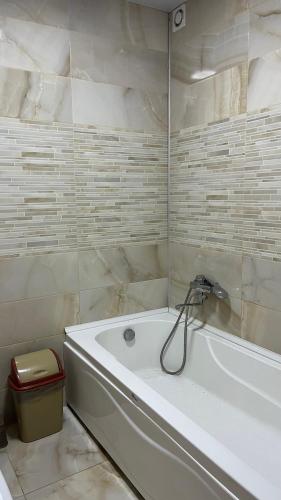 a white bath tub in a bathroom with marble walls at Marti in Ureki