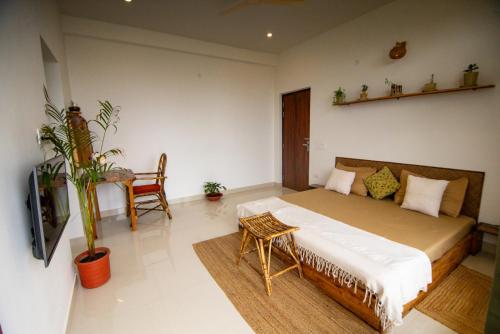 a bedroom with a bed and a table and a tv at The Jungalow by AVVAs Stays in Bīr