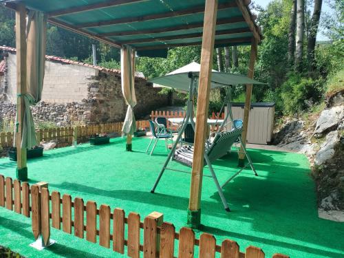 acovered patio with two chairs and an umbrella at Casa El Pastor in Valcovero