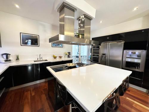 une cuisine avec une grande île blanche dans l'établissement Appartement spacieux Arc de Triomphe Paris, à Paris