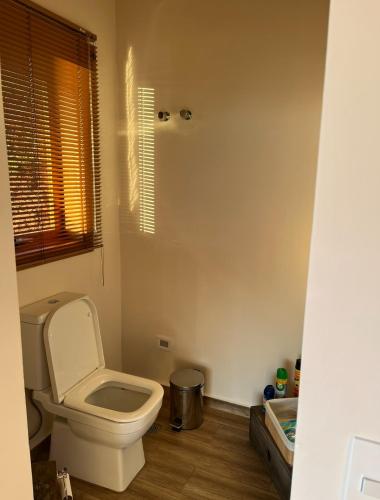 a bathroom with a toilet and a window at Cabana Girassol com piscina aquecida e cesta para café da manhã in Gonçalves