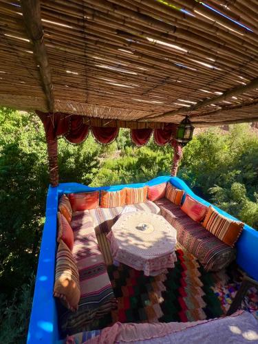 a couch sitting under a pergola with a table at Maison d'hôte Riad Todra in Tinerhir