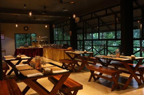 a dining room with wooden tables and a bar at Vajra Ayurveda and Yoga Retreat in Cochin