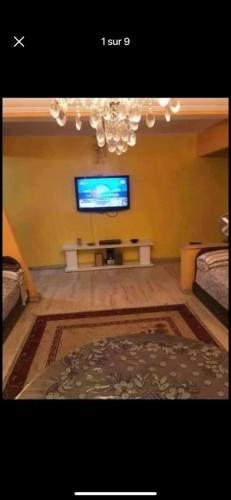 a living room with a tv on a wall at شارع اميل زول بلفدير الدار البيضاء المغرب in Casablanca