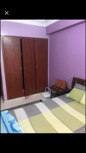 a bedroom with two beds and a cabinet at شارع اميل زول بلفدير الدار البيضاء المغرب in Casablanca