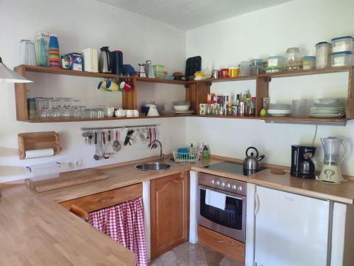 a kitchen with wooden cabinets and a sink at Villa Beata Apartment 1 upper floor in Kulen Vakuf