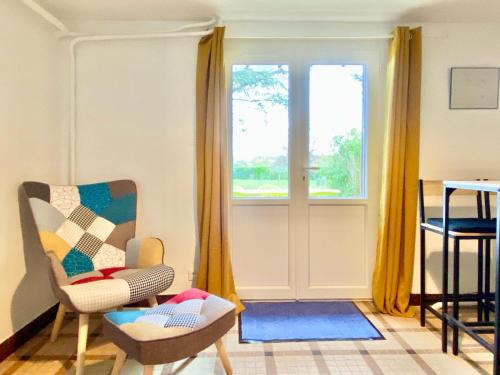 un salon avec une chaise et une fenêtre dans l'établissement La Caravelle 2 pièces sur jardin, à Montrichard
