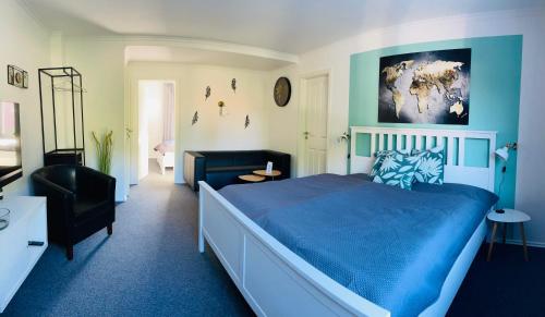 a bedroom with a blue bed and a black chair at Tohuus1875 in Warendorf