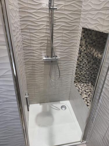 une douche avec une porte vitrée dans une salle de bain dans l'établissement Appartement idealement situé, à Nice