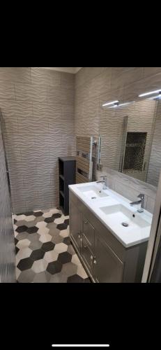 La salle de bains est pourvue de 2 lavabos et d'un sol en damier. dans l'établissement Appartement idealement situé, à Nice