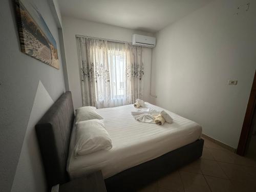 a bedroom with a bed with two teddy bears on it at Skenderi Apartments in Ksamil