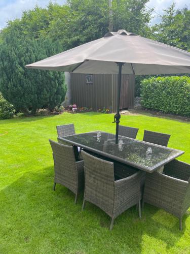 a table and chairs under an umbrella in a yard at 15 Cluain Caoin Nenagh in Nenagh