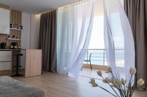 a living room with a couch and a large window at Mateo Apartments in Sarandë