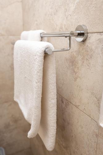 a pair of towels hanging on a wall in a bathroom at iVAVev IS US ByTheSea EforieSud in Eforie Sud