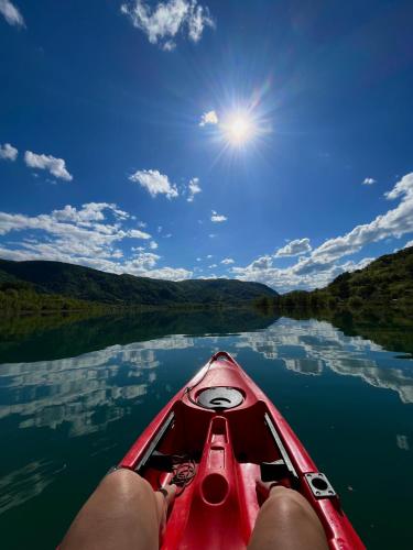 a person sitting in a red canoe on a lake at Delta Lake House 1 in Velika Reka