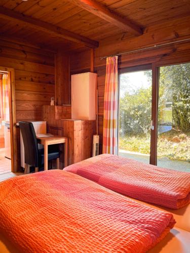 a bedroom with a bed and a table and a window at Haus Lahneck bei Koblenz in Lahnstein