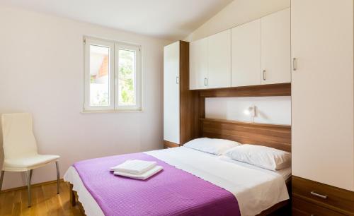a bedroom with a large bed with a purple blanket at Apartment Mia - Spacious apartment on 85 m2 with beautiful sea view in Trogir