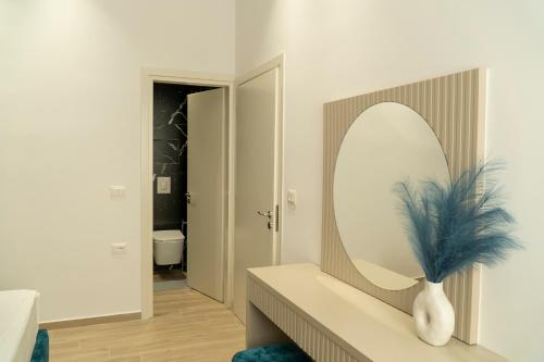 a bathroom with a mirror and a vase on a counter at Mateo Apartments in Sarandë