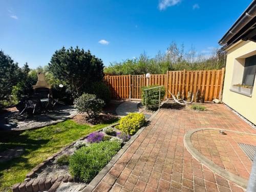 a backyard with a fence and a brick driveway at Strandliebe Markgrafenheide in Rostock