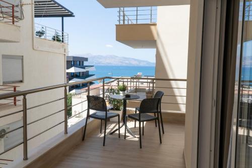 a balcony with a table and chairs and a view of the ocean at Mateo Apartments in Sarandë