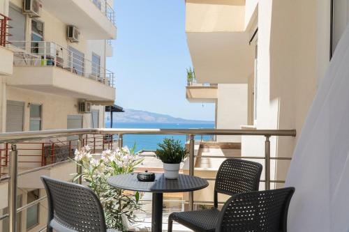 a balcony with a table and chairs and a view of the ocean at Mateo Apartments in Sarandë