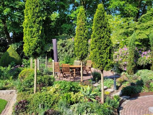 a garden with a table and chairs and trees at Villa in Overloon near War Museum and Zoo in Overloon