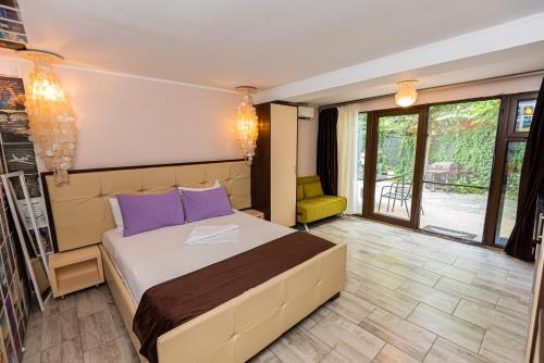 a bedroom with a large bed with purple pillows at iVAVev IS US ByTheSea EforieSud in Eforie Sud