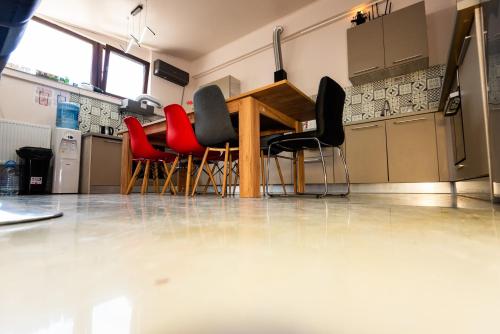 a dining room with a table and red chairs at iVAVev IS US ByTheSea EforieSud in Eforie Sud
