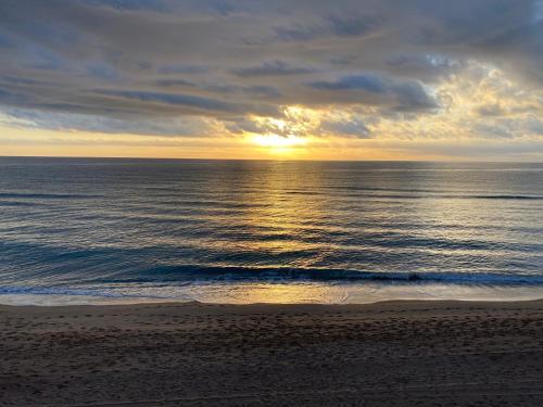 a sunset over the ocean on a beach at Caballito de Mar in Tavernes de Valldigna