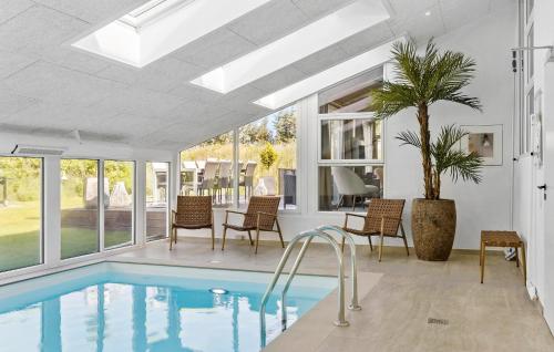 a swimming pool in a house with a palm tree at 4 Bedroom Nice Home In Saltum in Saltum