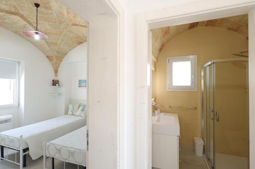a bathroom with a bed and a sink in a room at Villa Brezza dello Ionio in Marina di Pescoluse