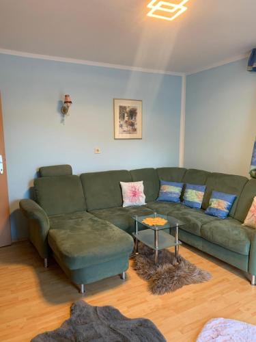 a living room with a green couch and a table at Ferienwohnung Marianne in Annaberg im Lammertal