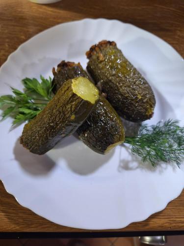 a plate of food with pickles on a table at Joan Guesthouse in Përmet