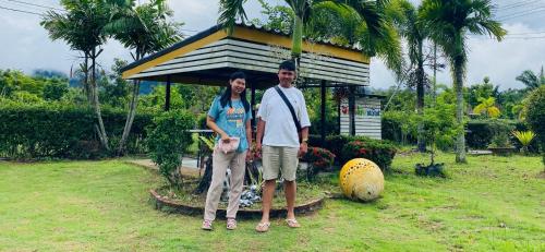 two men standing in front of a small building at Panutsaya Homestay in Wang Nam Khieo