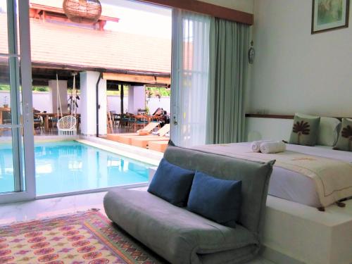 a bedroom with a bed next to a swimming pool at Keramas Moonlight Villa in Keramas
