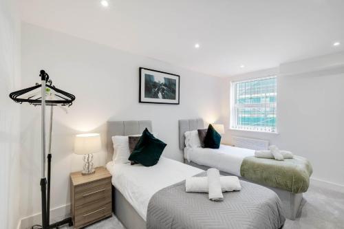 a bedroom with two beds and a window at Modern 2 Bedroom Apartments Town Centre Camberley in Camberley