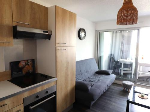 un salon avec un canapé et une cuisine dans l'établissement Studio cabine rénové climatisé proche plage pour 4 pers - FR-1-307-206, au Grau-du-Roi