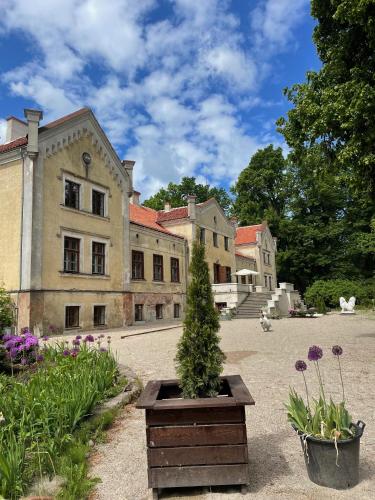 a house with a christmas tree in a courtyard at Ķimales muiža in Ķimale