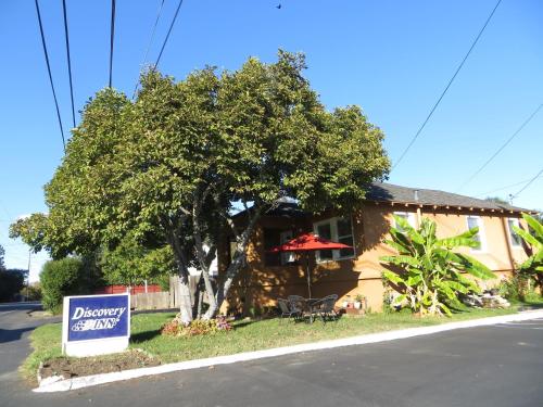 a sign in front of a house with a tree at Napa Discovery Inn in Napa
