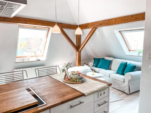 キールにあるStilvolle Dachgeschosswohnung in Düsternbrookのキッチンとテーブルとソファのあるリビングルーム
