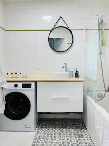 une salle de bain avec une machine à laver et un lavabo dans l'établissement Le Studio de Jeanne, à Mont-de-Marsan