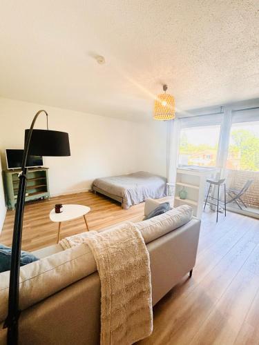 un salon avec un canapé et un lit dans l'établissement Le Studio de Jeanne, à Mont-de-Marsan