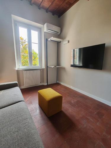 a living room with a couch and a yellow stool at L'Appartamento di Jò in Lucca