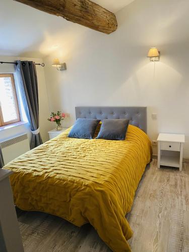 a bedroom with a large bed with a yellow blanket at La Vieille Demeure in Torreilles