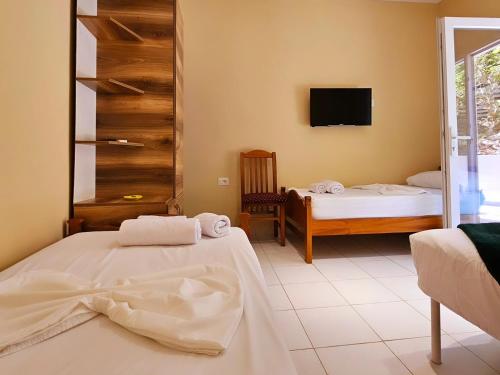 a bedroom with two beds and a tv on the wall at Lemon House Borsh in Himare