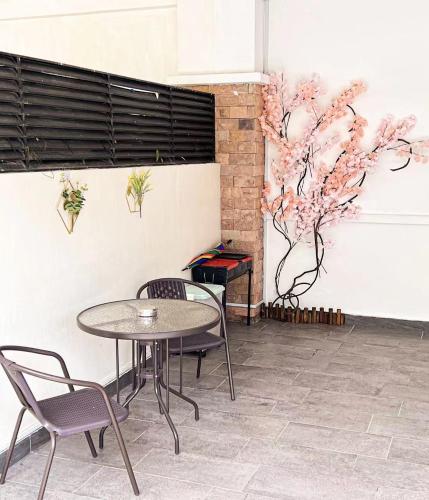 a table and chairs in a room with flowers on the wall at 嘉乐民宿JIALE homestay in Kota Kinabalu